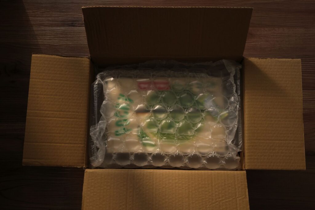 Bubble-wrapped electronic device packed securely in a cardboard shipping box